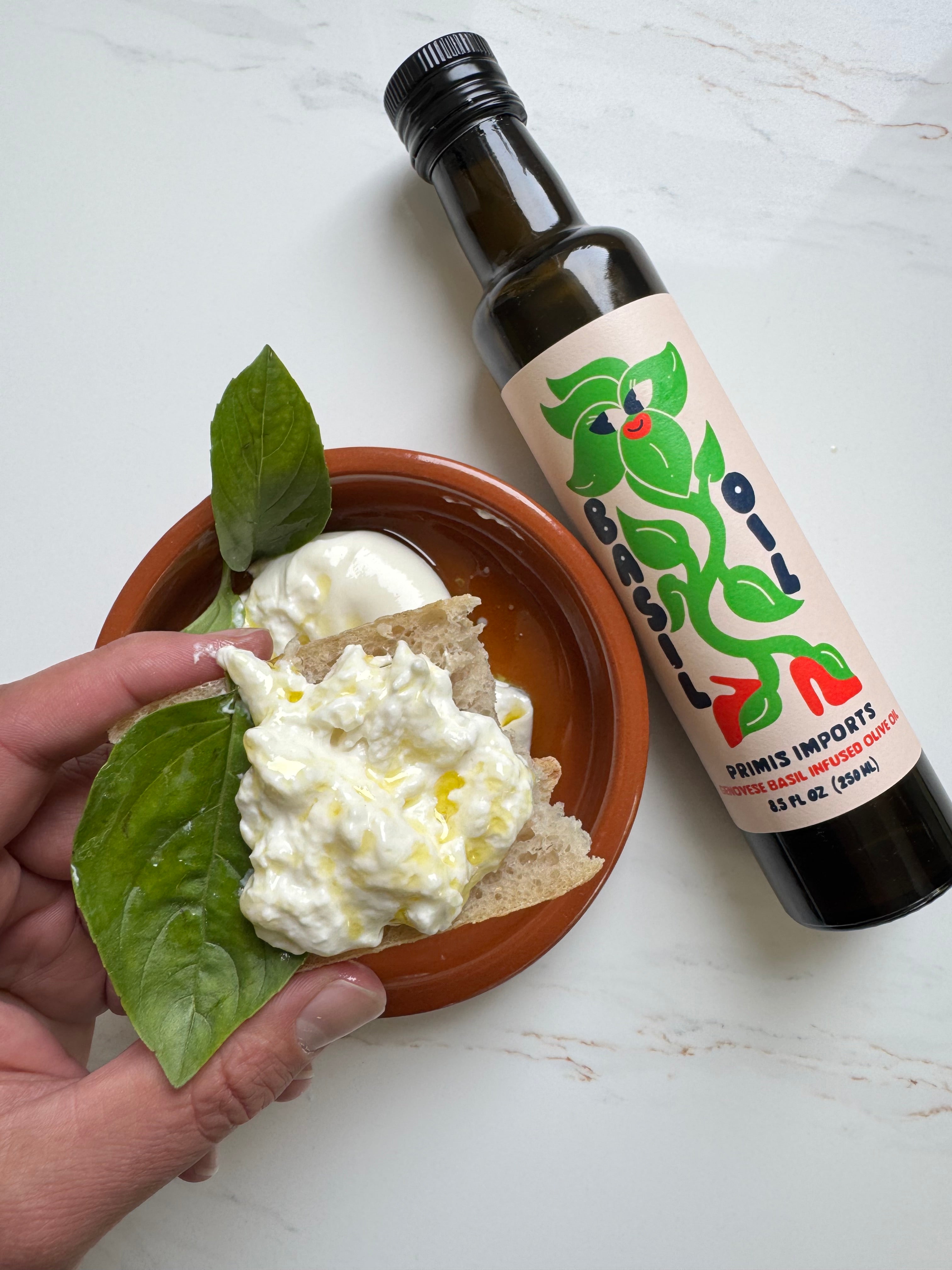 Torn burrata drizzled with Genovese basil infused olive oil and Greek sea salt flakes, served with crusty bread