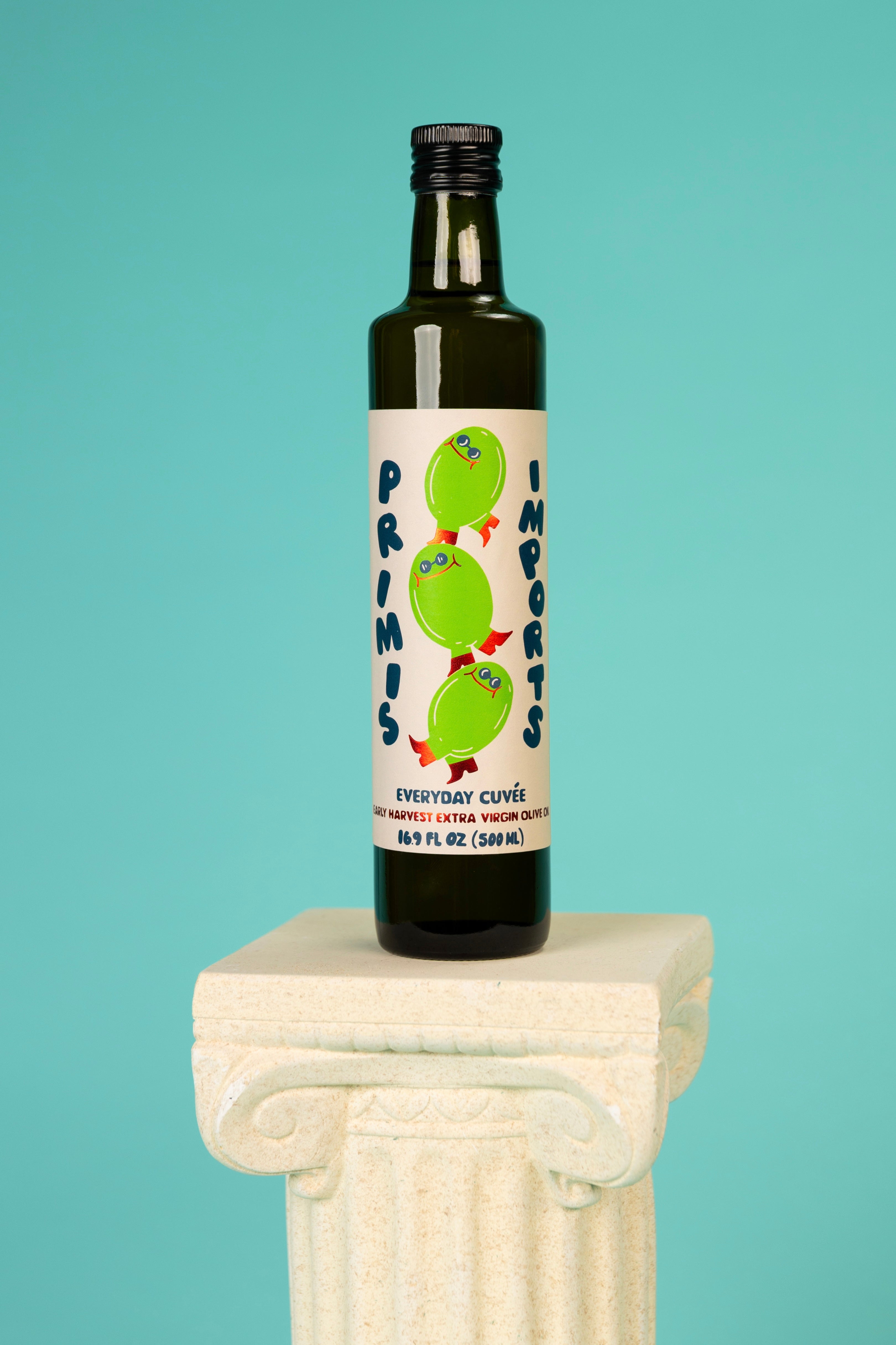 Bottle of 'Primis' olive oil on a decorative pedestal against a teal background